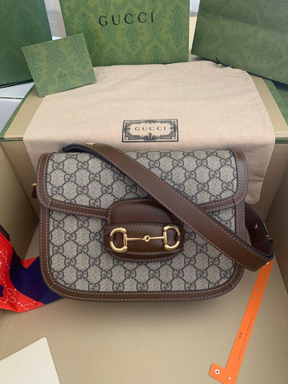 Bolsa estampada com alça marrom e ferragens douradas